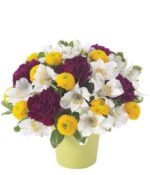 Bouquet of chrysanthemum, carnation, craspedia and lilies in a light green vase